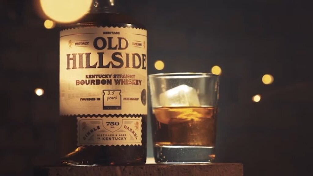 Jesse Carpenter, co-founder of Old Hillside Bourbon, stands holding a bottle of the Durham-inspired bourbon brand he launched with fellow Hillside High School alumni.